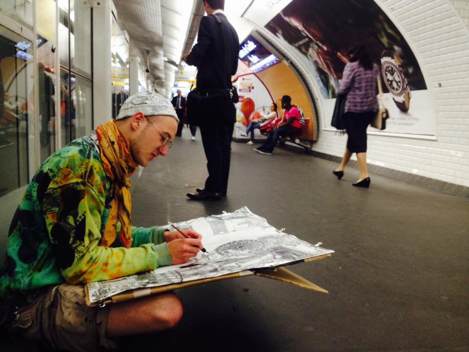 An artist creating street art in a Paris subway tunnel at Charles de Gaulle Étoile station, showcasing urban art in a vibrant, underground setting.